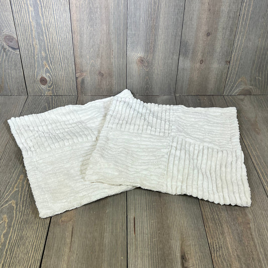 Cream corduroy throw pillow covers with cross patchwork on rustic wooden background, ideal for farmhouse decor.