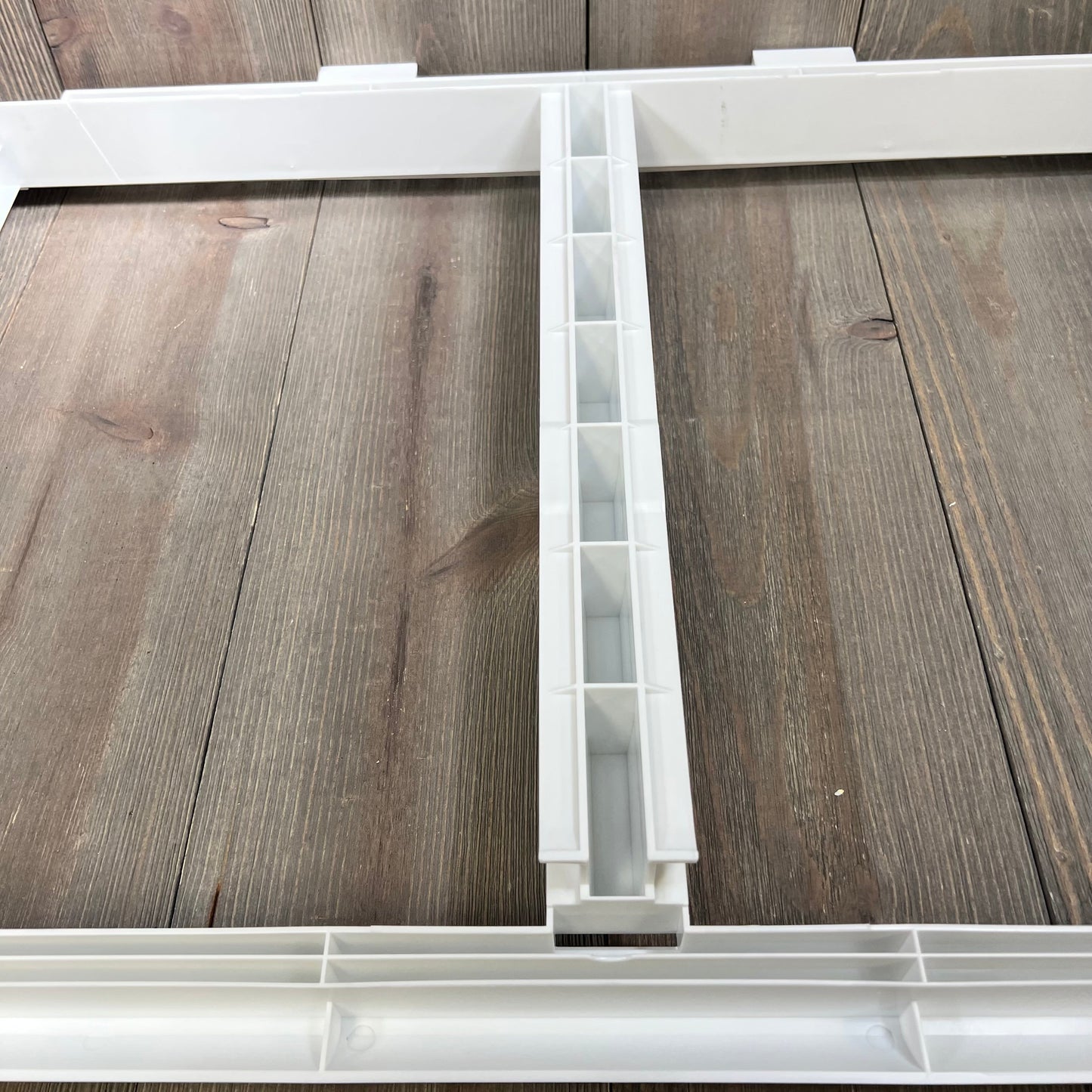 Crisper drawer cover frame with detailed grid design, compatible with Frigidaire models, on wooden surface.