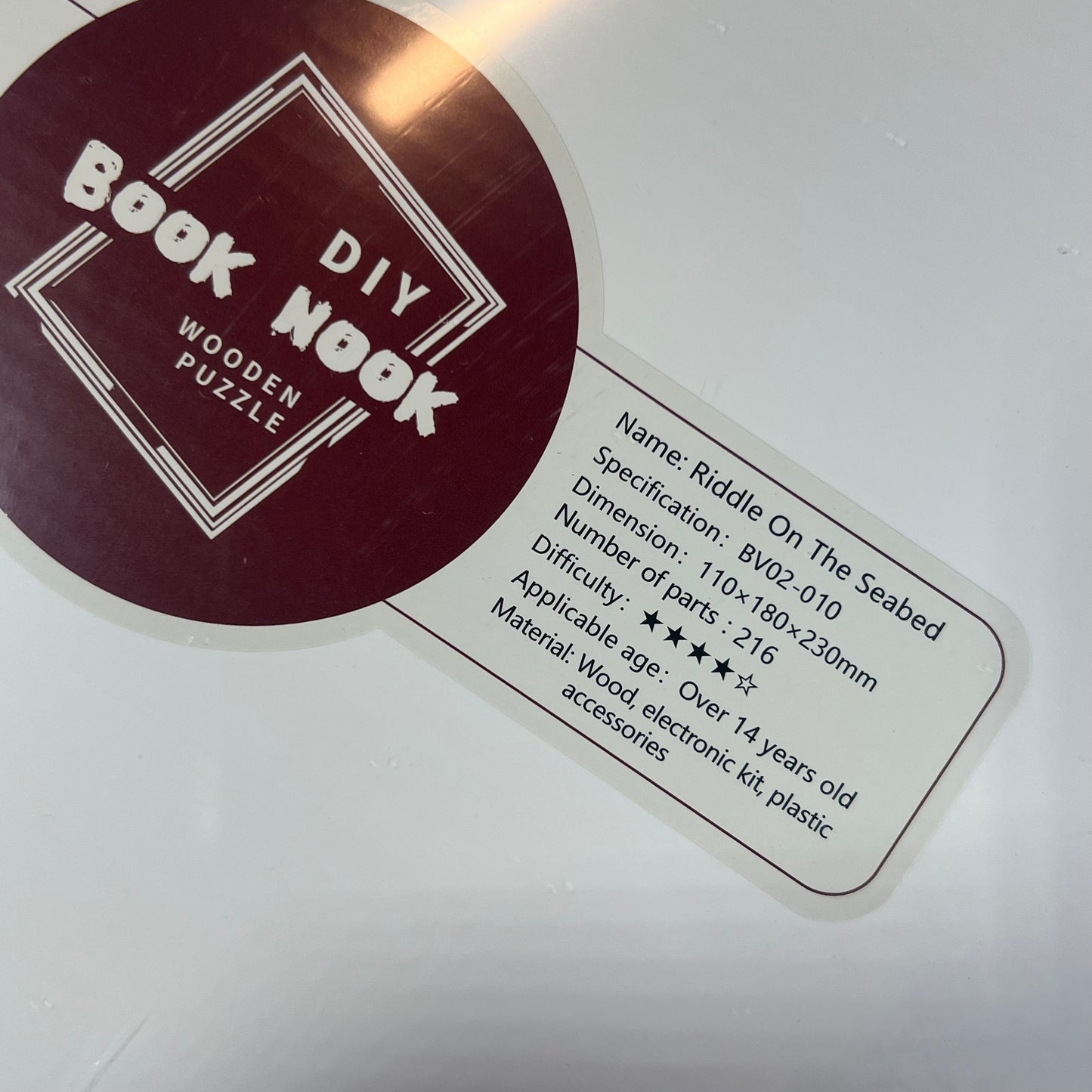 DIY Book Nook Kit label displaying dimensions, difficulty, and materials for the Seabed Riddle miniature dollhouse.