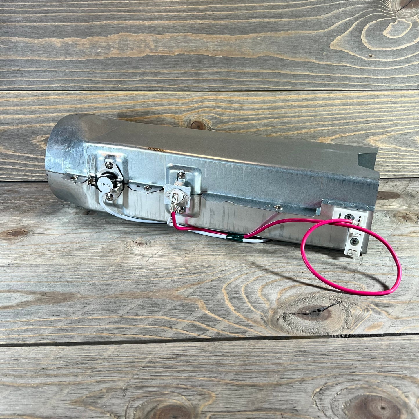 Dryer heating element 1048541548-5301EL1001H for LG and Kenmore, showcasing metal casing and wiring on wooden background.
