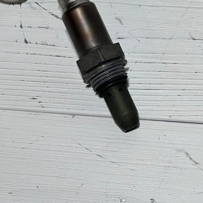 Upstream oxygen sensor for Nissan Rogue 2.5L, 2010-2013, shown on a white wood background.