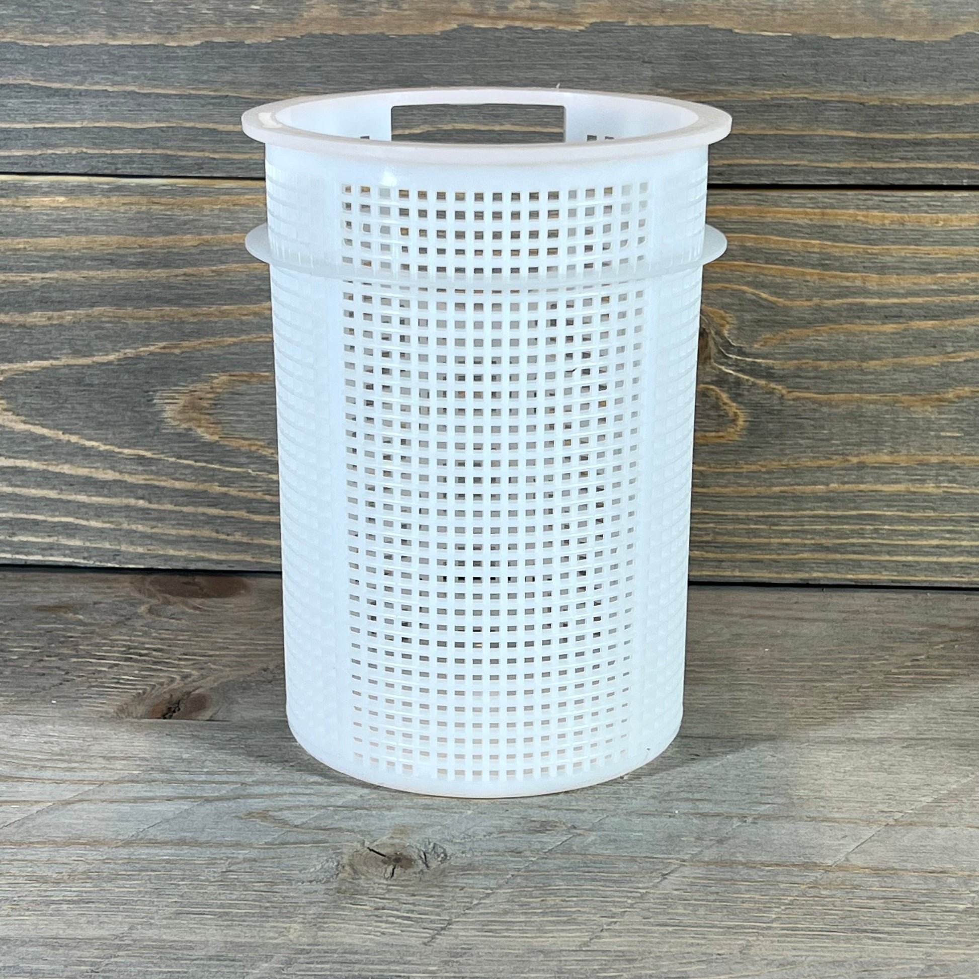 Durable Pentair strainer basket for Sta-Rite suction trap assembly on wooden background.
