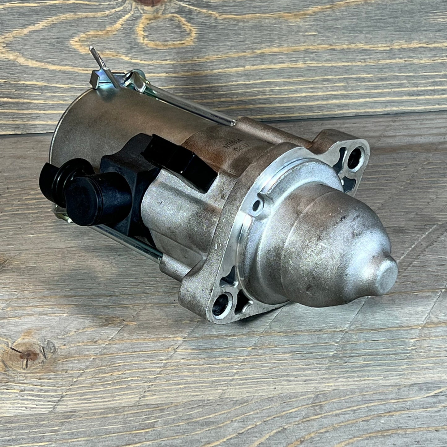 Durable starter motor for Honda Accord 2013-2017, featuring robust metal construction on wood background.