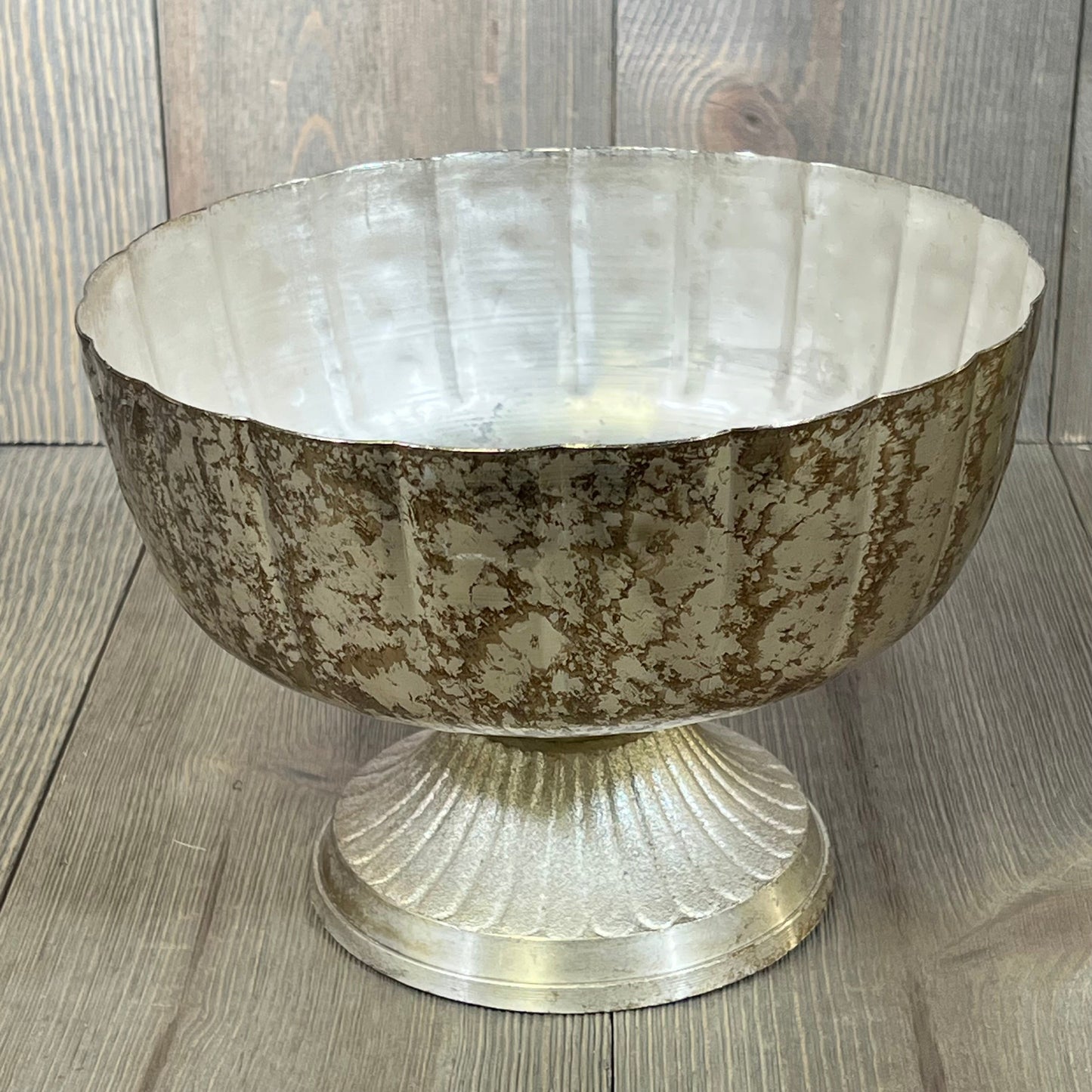Distressed champagne metal compote bowl with pedestal base, perfect for elegant indoor or outdoor event decor.