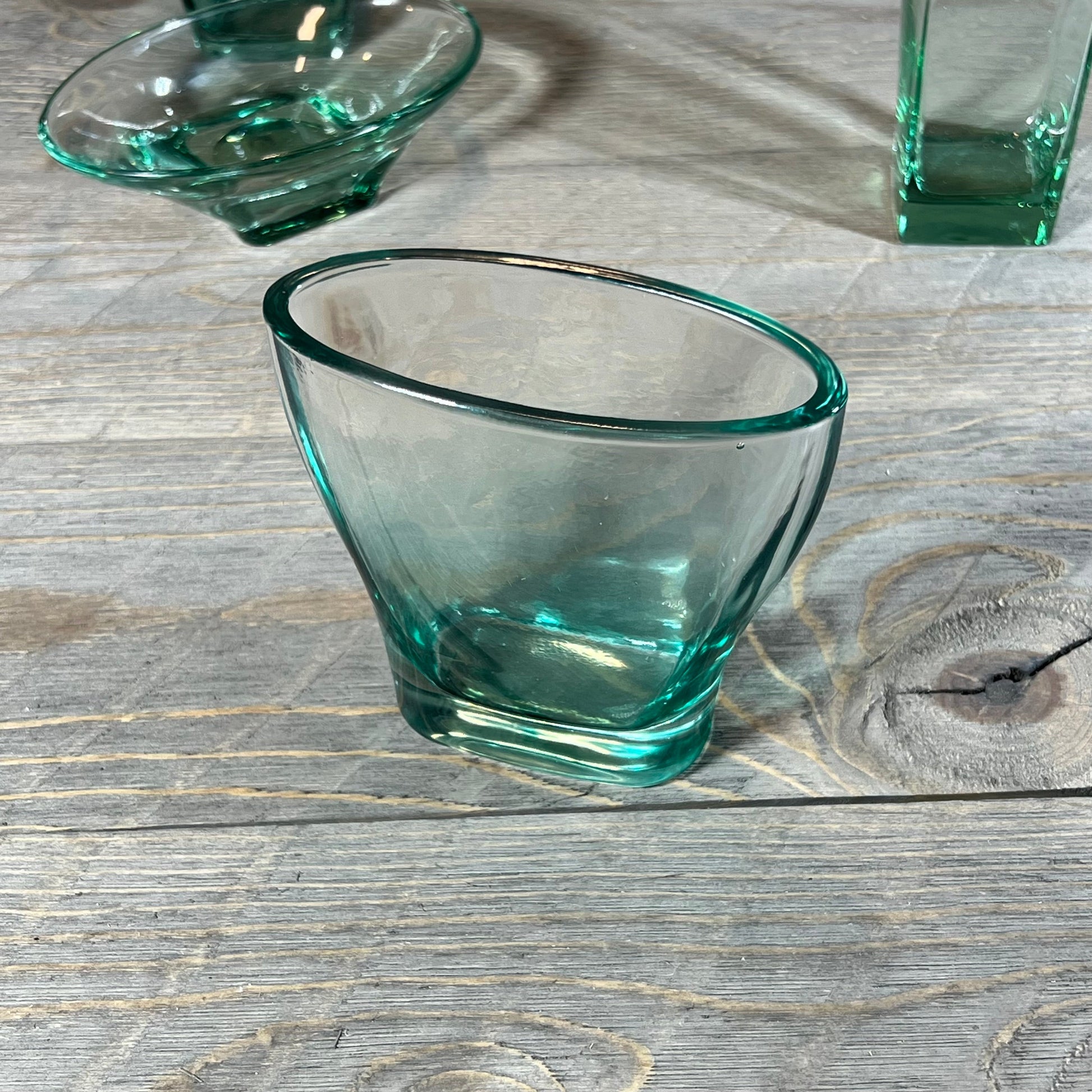 Elegant teal glass tumbler from the Green Teal Glass Bathroom Accessory Set on rustic wooden surface.