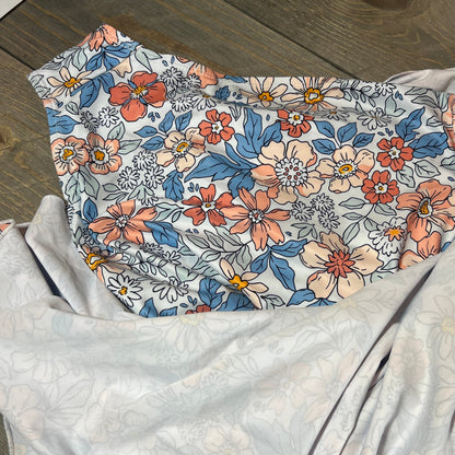 Floral pattern on Eomenie swimdress with tummy control, showcasing vibrant colors on a wooden background.