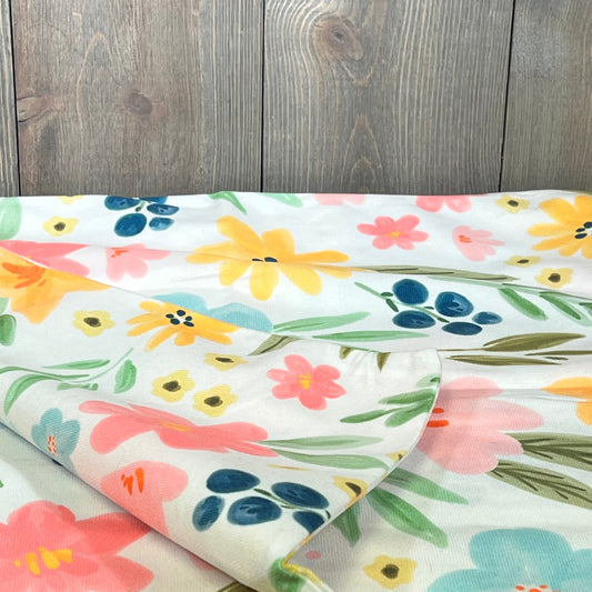 Watercolor floral pillow covers with yellow, pink, and blue flowers on a rustic background, ideal for spring decor.