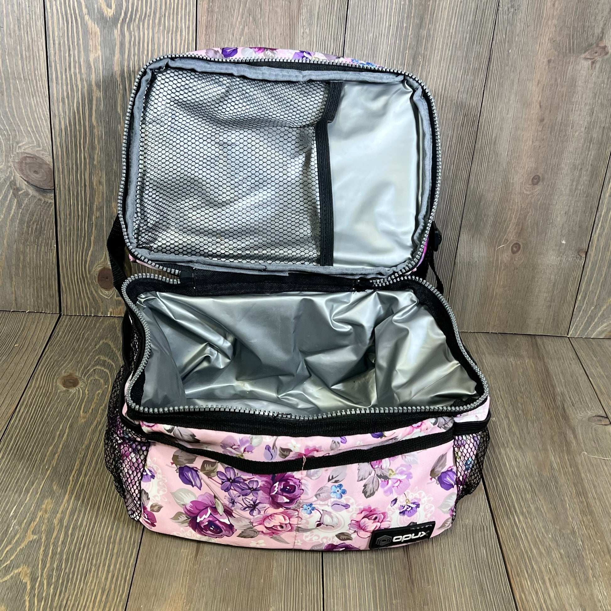 Floral purple lunch box with dual compartments open, showcasing spacious insulated interior on wooden background.