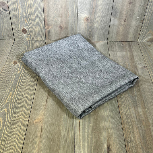 Folded grey textured linen tablecloth on wooden surface, 60 x 104 inch, perfect for waterproof dining and spring decor.