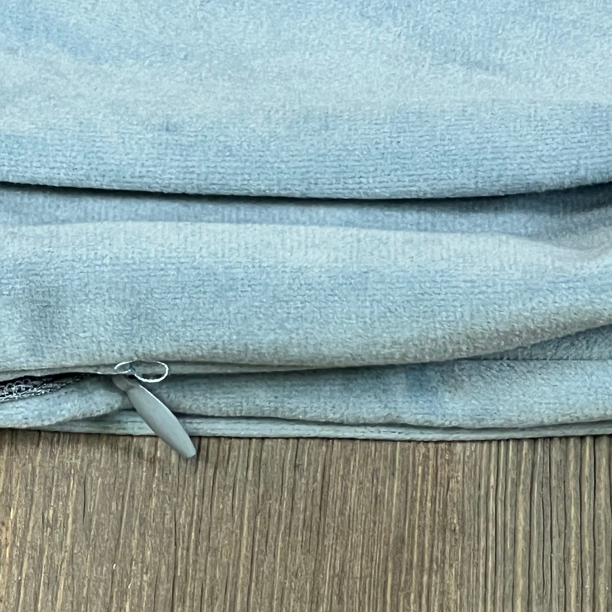 Silver blue velvet cushion covers with zipper detail, 20x20 inch, on wooden surface. Ideal for bed, couch, or sofa decor.