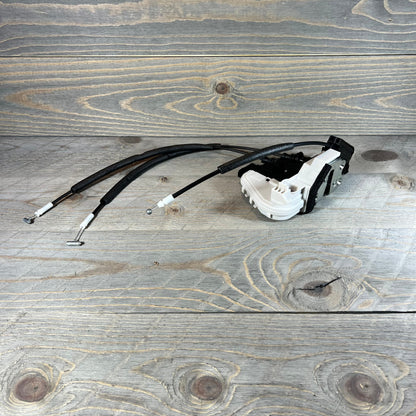 Front right door lock actuator for 2013-2019 Hyundai Santa Fe, replacement part with cables on wooden background.