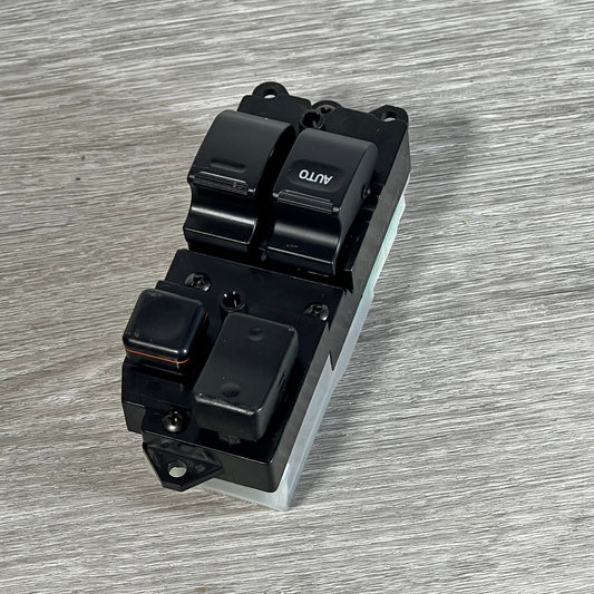 Front view of Dorman 901-711 driver side window switch for Toyota, showcasing button layout on wood surface.