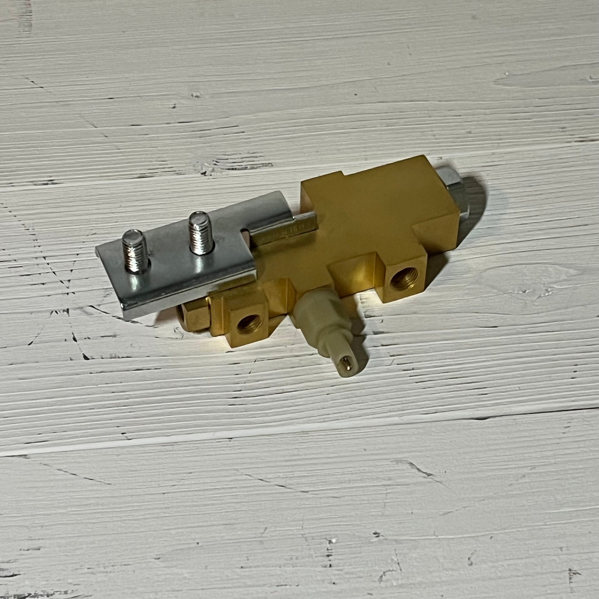 Gold brake proportioning valve for Ford Mustang 1964-1970 on a white wooden surface.