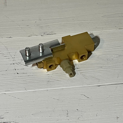 Gold brake proportioning valve for Ford Mustang 1964-1970 on a white wooden surface.