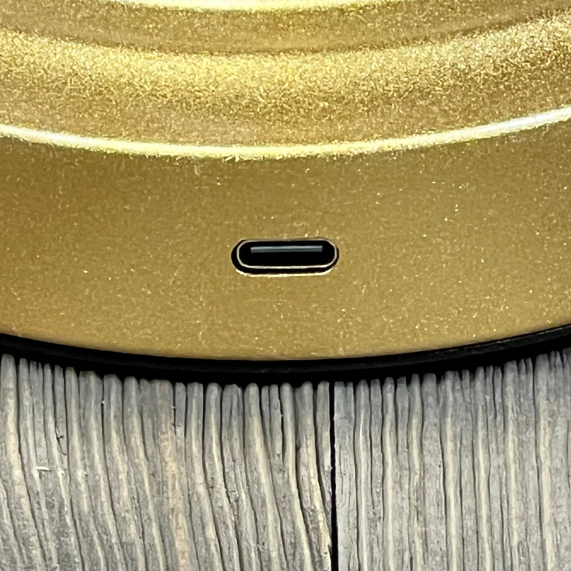 Gold rechargeable rattan table lamp with USB-C port for efficient charging on bedside or countertop.
