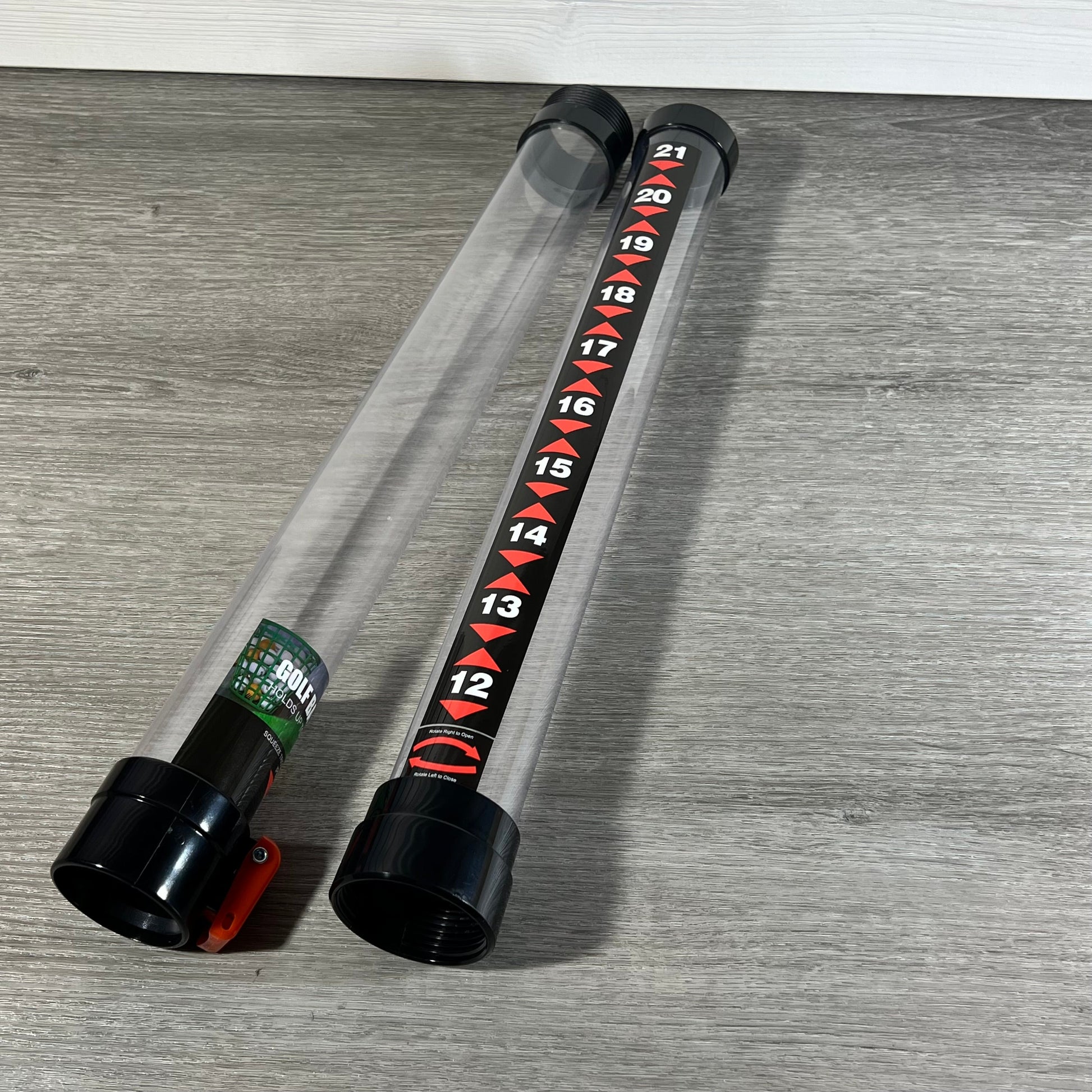 Golf ball retriever tool with clear 36-inch tube, marked for 21 balls, on wooden floor.