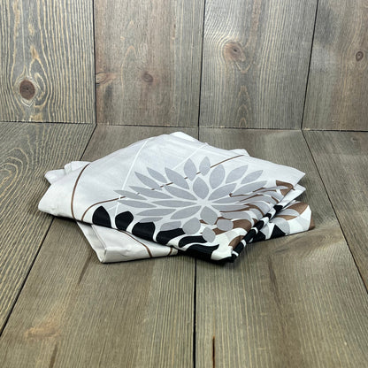 Folded DFXSZ outdoor pillow covers with elegant black and brown geometric design on rustic wooden background.
