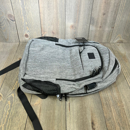 Grey MATEIN travel laptop backpack on wooden floor, featuring anti-theft design and USB charging port.