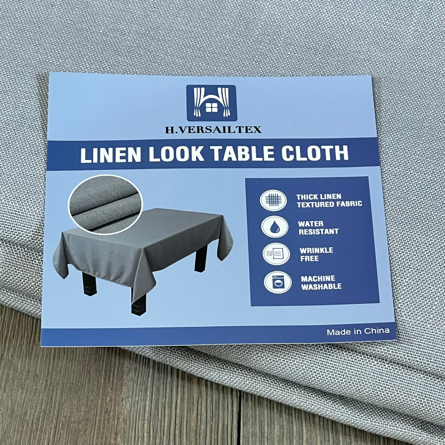 H.VERSAILTEX grey linen textured tablecloth, 60x104 inch, wrinkle-free, waterproof, shown with packaging and fabric detail.