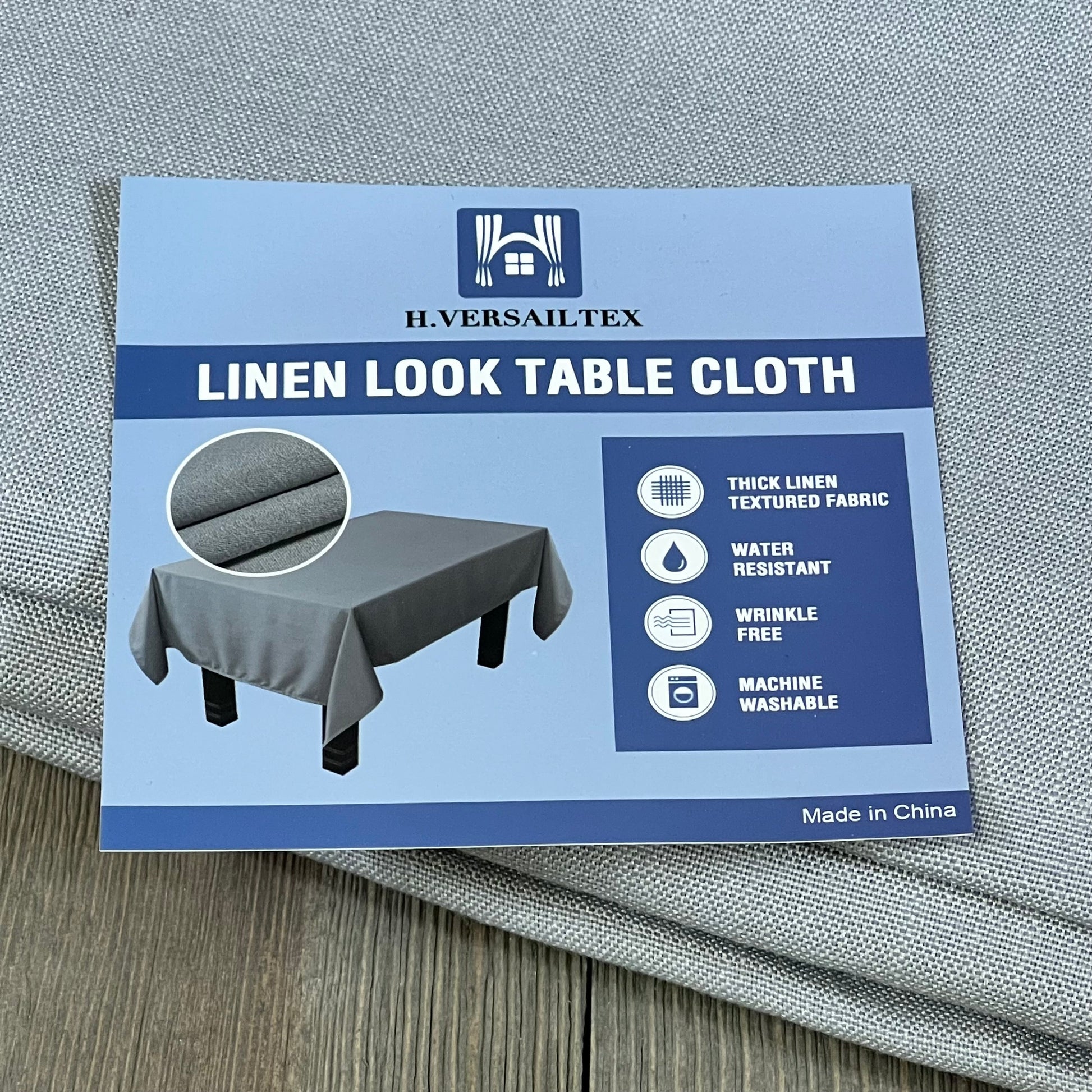 H.VERSAILTEX grey linen textured tablecloth, 60x104 inch, wrinkle-free, waterproof, shown with packaging and fabric detail.