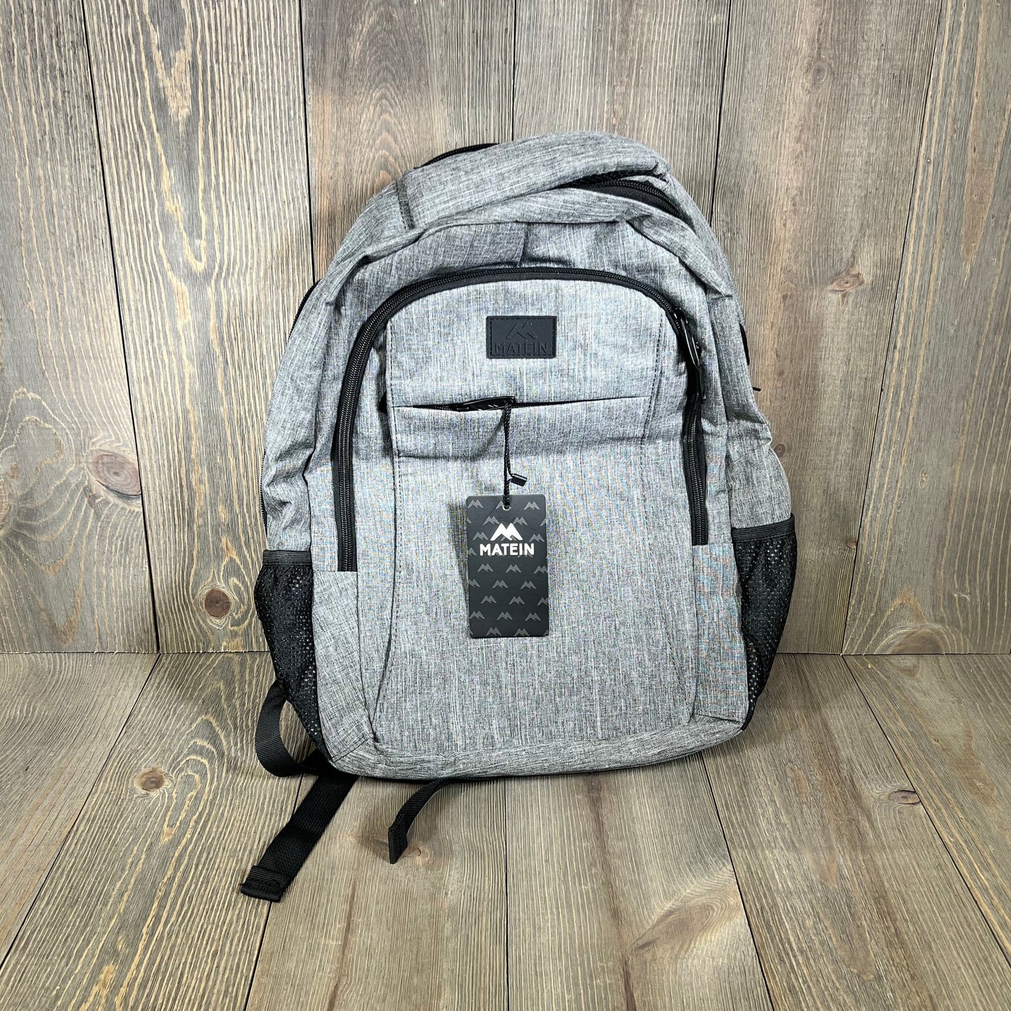 Grey MATEIN travel laptop backpack with USB charging port, ideal for 15.6-inch notebooks, featuring a sleek anti-theft design.