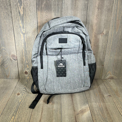 Grey MATEIN travel laptop backpack with USB charging port, ideal for 15.6-inch notebooks, featuring a sleek anti-theft design.