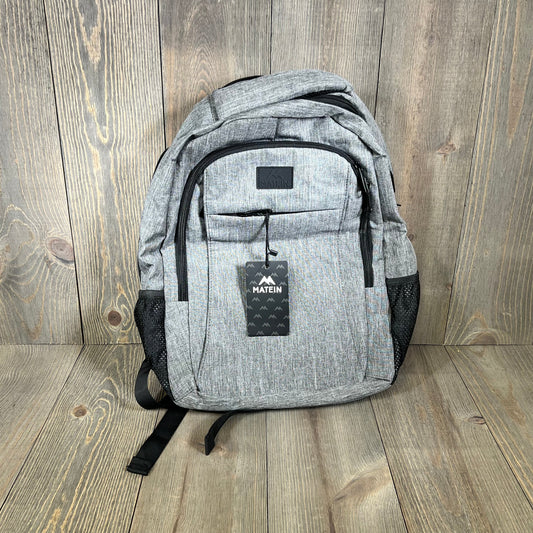 Grey MATEIN travel laptop backpack with USB charging port, ideal for 15.6-inch notebooks, featuring a sleek anti-theft design.