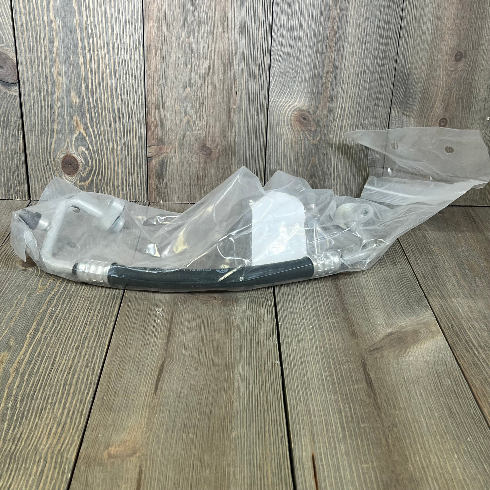 Premium A/C discharge line hose assembly for Jeep Wrangler 2007-2011, shown in protective packaging.