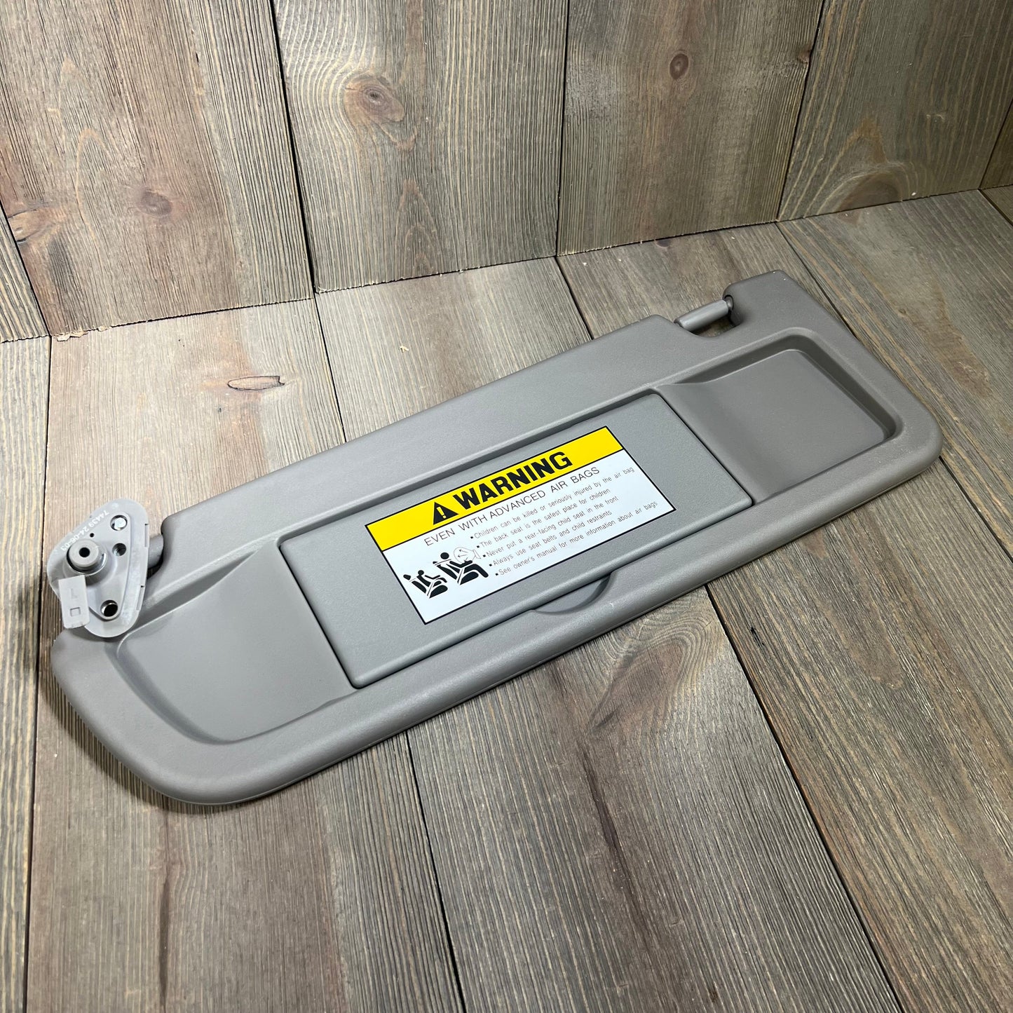 Gray Dorman 74439 driver side sun visor for Honda models, featuring warning label and sturdy construction.