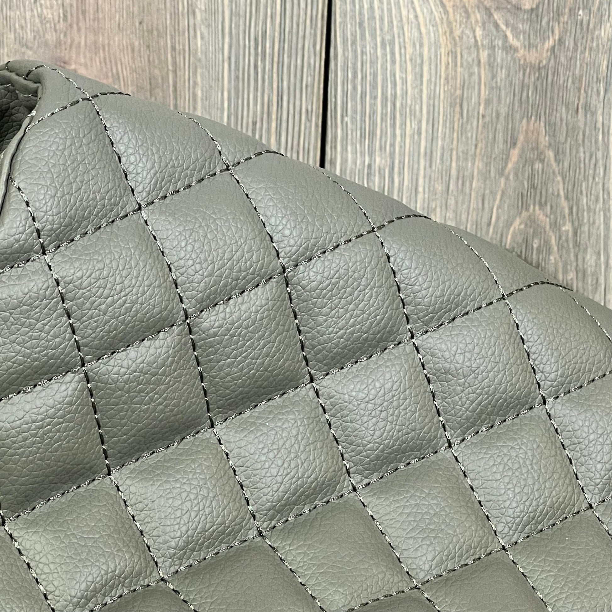 Quilted gray leather armrest cover for Ford F250-F450, featuring durable stitching and sleek design.