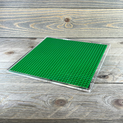 Green acrylic building brick display shelf, 10x10 inch, for minifigures, compatible with major brands, on wooden surface.