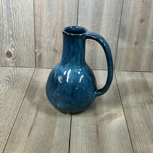 Blue ceramic vase with a large handle, showcasing a glossy finish, ideal for modern farmhouse decor on wooden background.