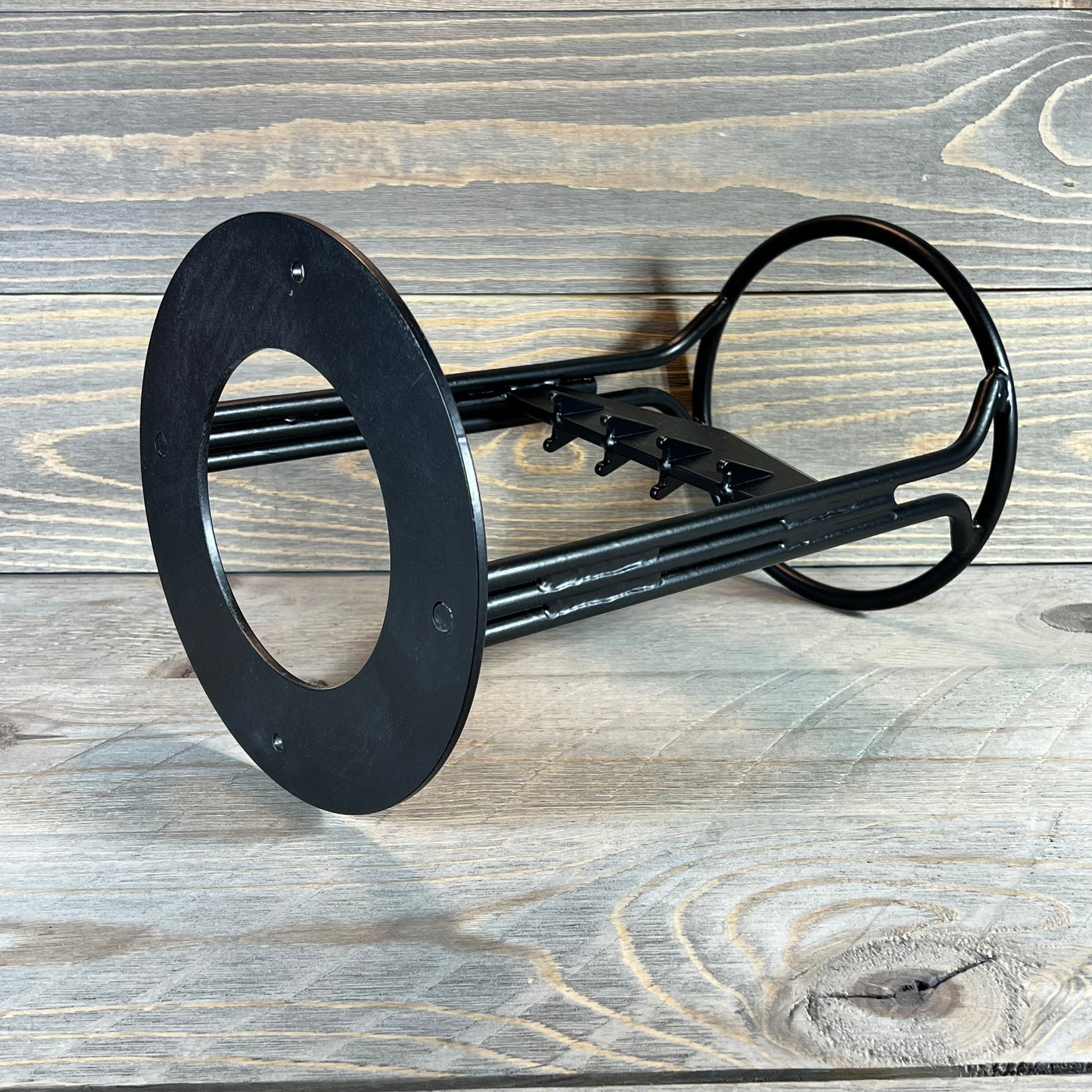 Heavy-duty manual log splitter wedge on rustic wooden background.
