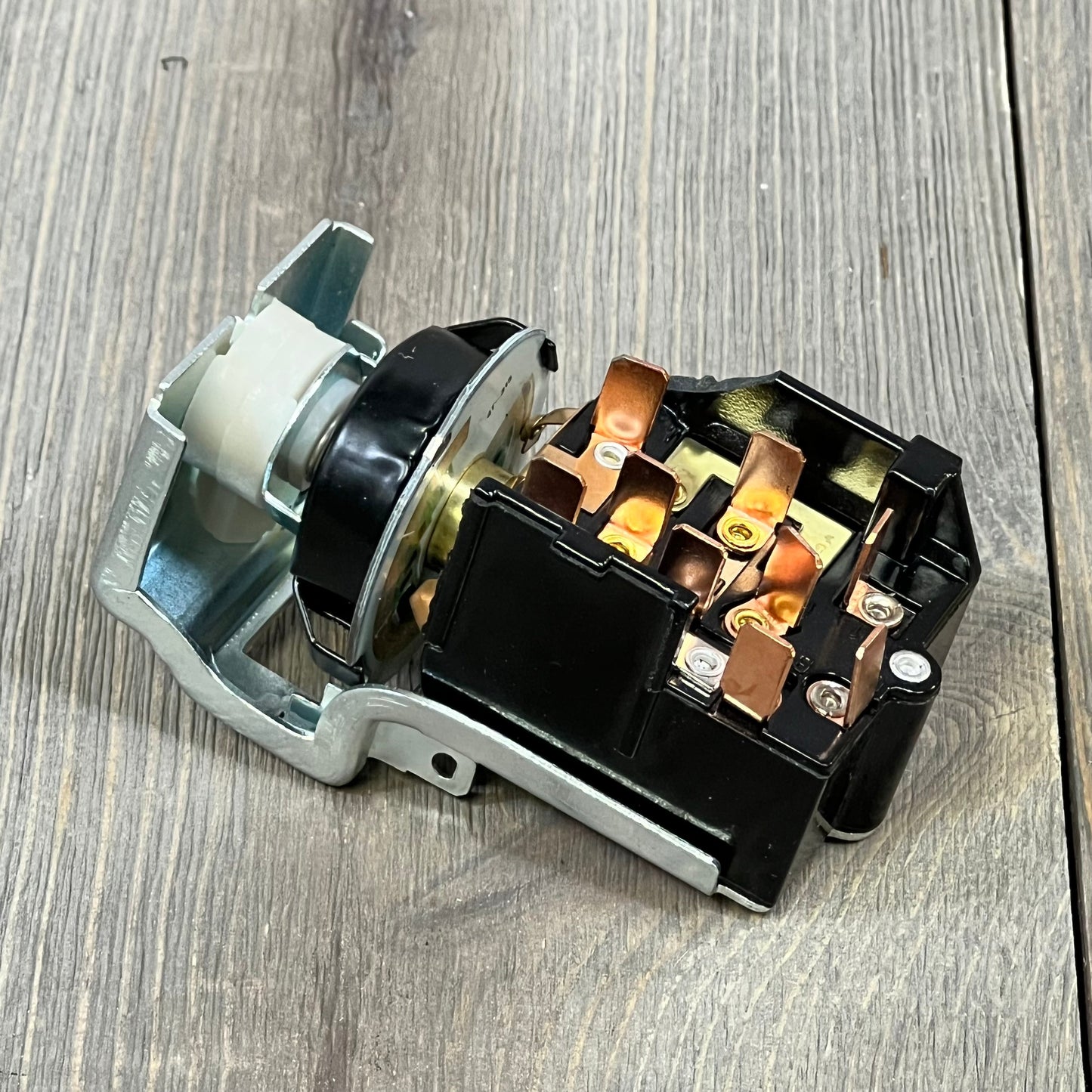 Durable headlight switch for Dodge Ram 1500/2500/3500, showcasing copper connectors and robust build on wood surface.