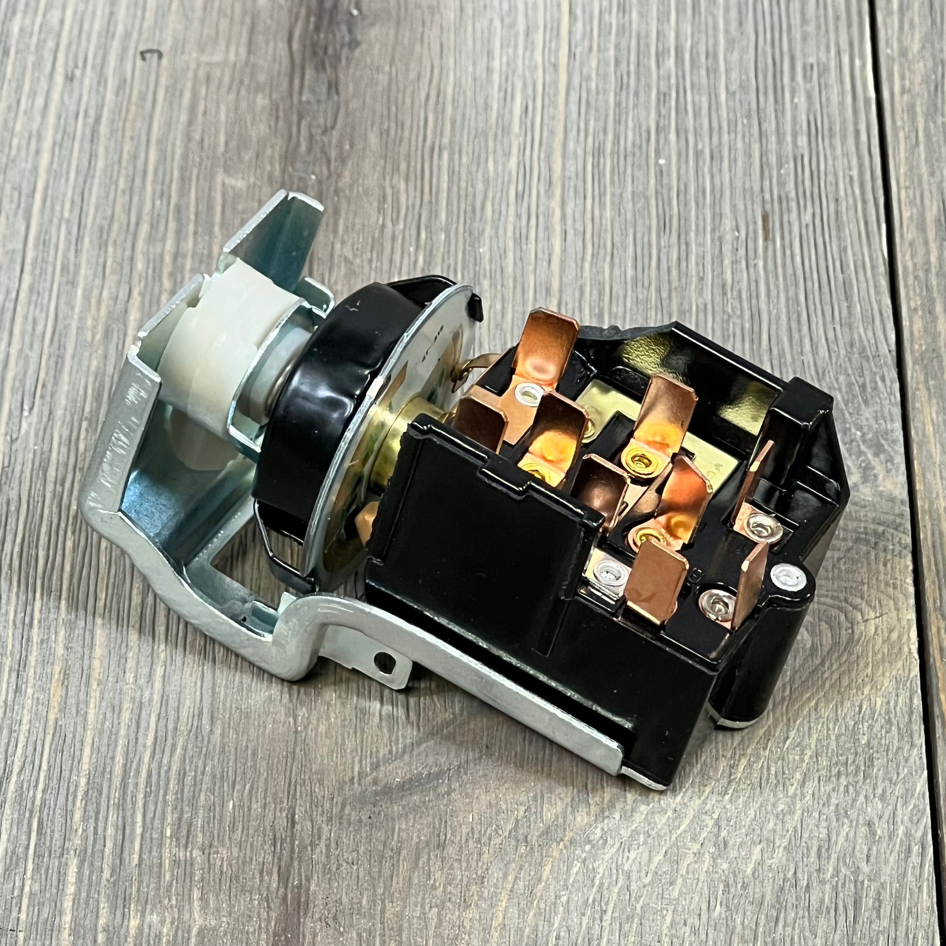 Durable headlight switch for Dodge Ram 1500/2500/3500, showcasing copper connectors and robust build on wood surface.