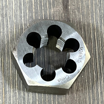 Drill America DWTSMH26X1.5 carbon steel hex rethreading die, showcasing M26 X 1.5 threading against a wooden backdrop.