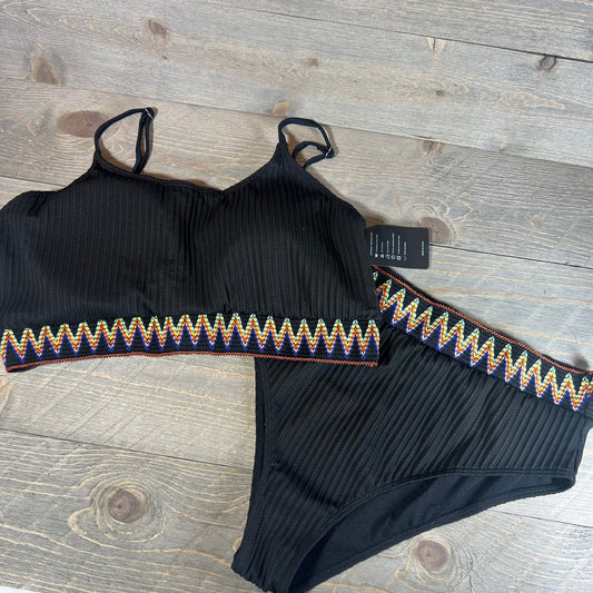 High waisted ribbed bikini set with colorful zigzag trim on a wooden background, size XXL.