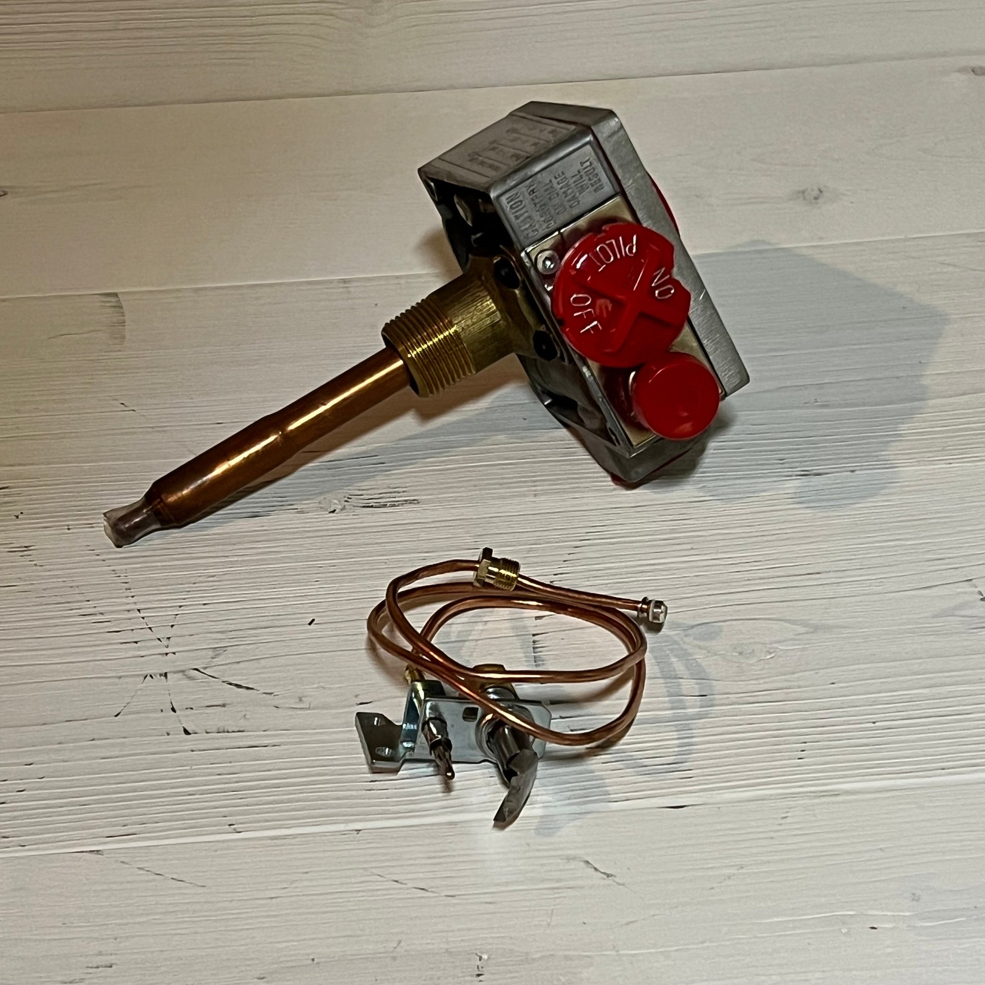 Gas water heater valve with red control knob and 1-3/8" shank, featuring copper tubing and mounting hardware for installation.