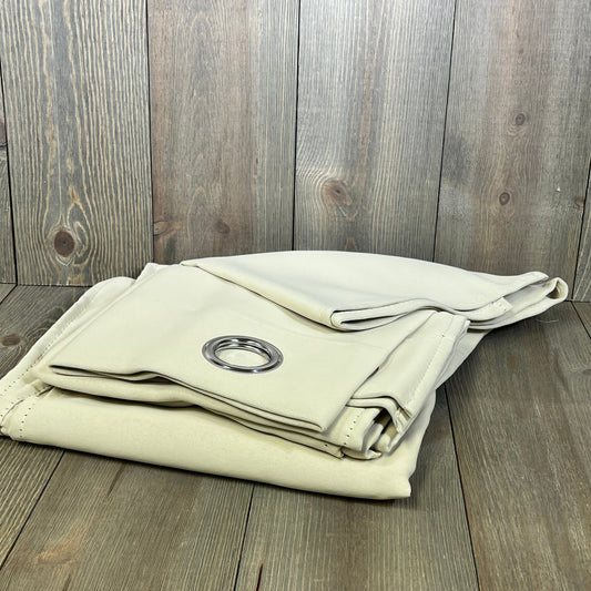 Beige thermal insulated kitchen curtains folded on wooden surface, featuring grommet detail for easy hanging.