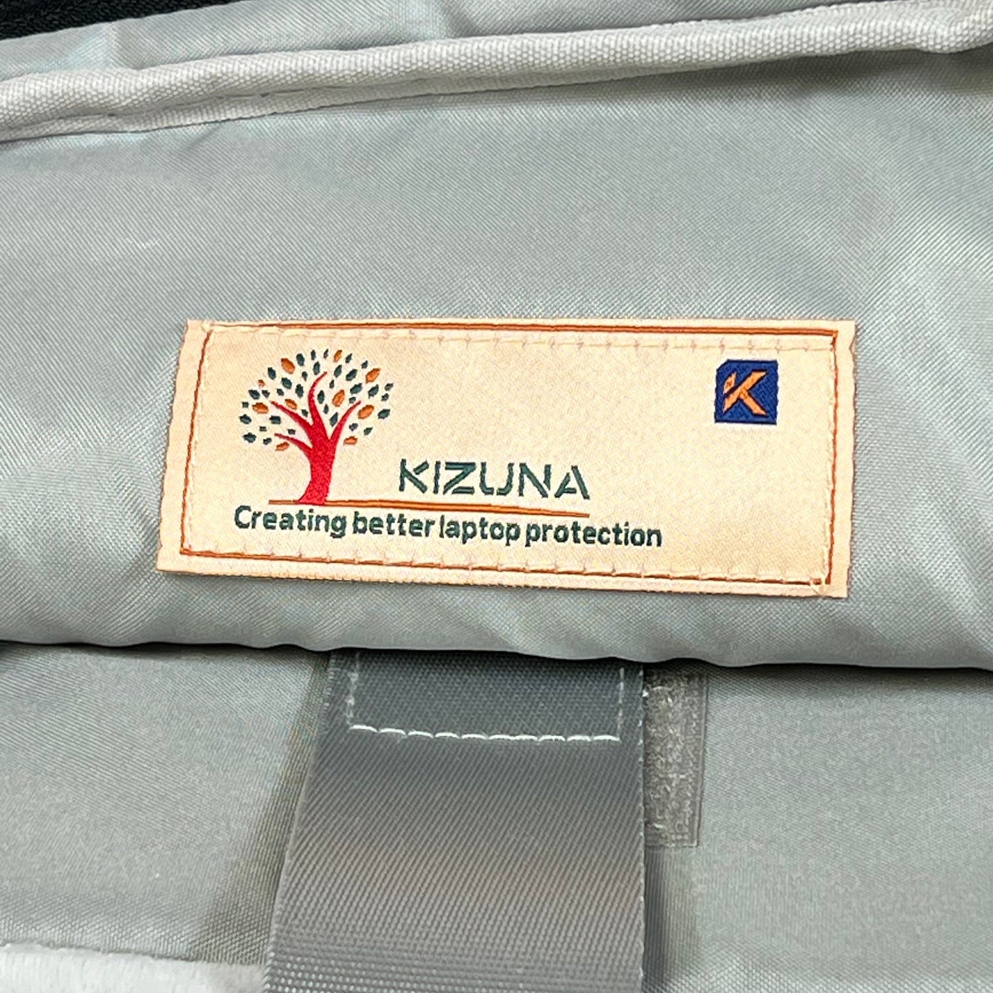 KIZUNA laptop bag interior label showing quality stitching and brand logo for 17-inch laptop protection.