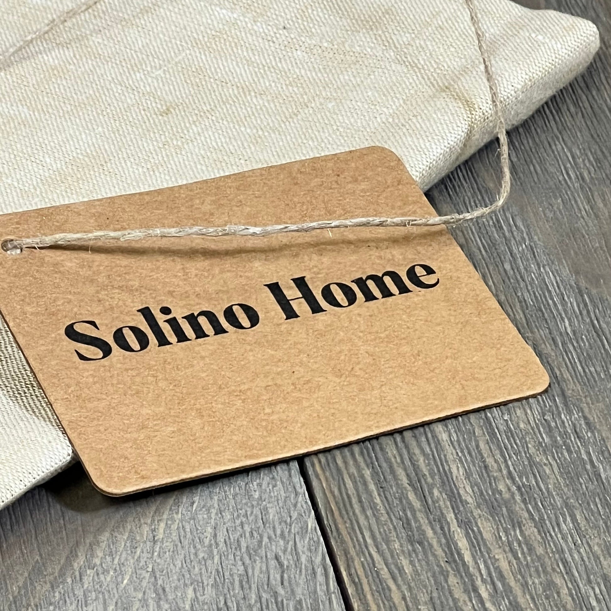 Solino Home tag on pure linen table runner in champagne beige, perfect for spring and summer decor on coffee tables.