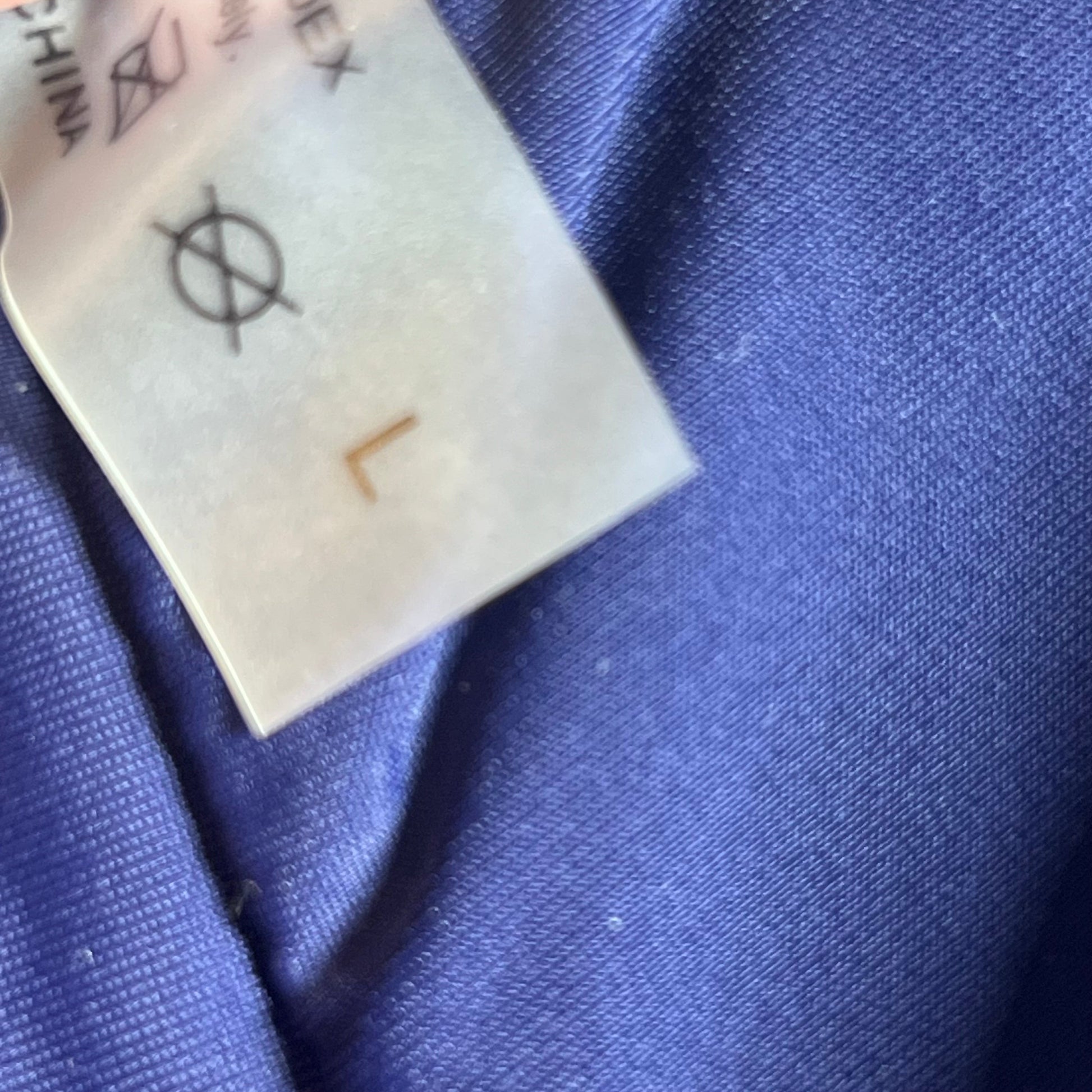 Label of Yonique Women's Blue Mandala Tankini Swimsuit in Size L, showing care instructions and fabric texture.