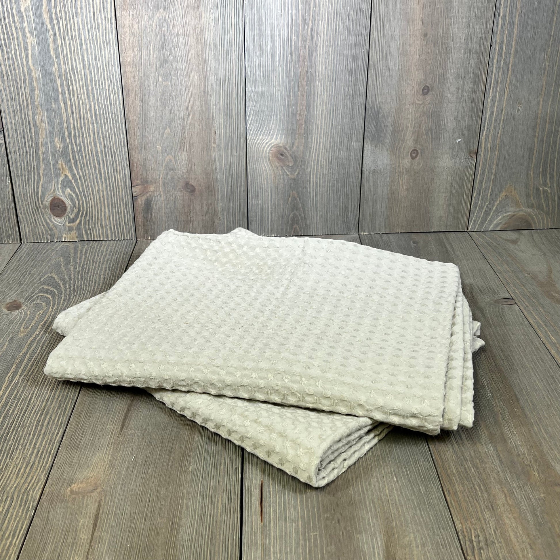 Light khaki waffle weave pillow shams on wooden surface, showcasing breathable texture and stylish design.