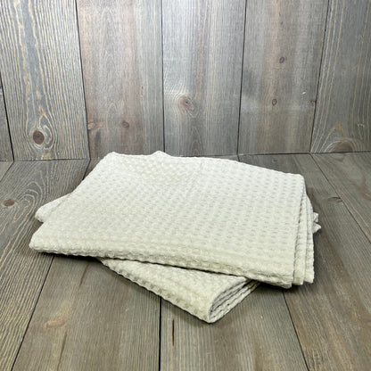 Light khaki waffle weave pillow shams on wooden surface, showcasing breathable texture and stylish design.