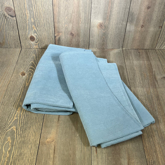 Light blue chenille pillow covers folded neatly, showcasing elegant design and soft texture, perfect for couch or bed decor.