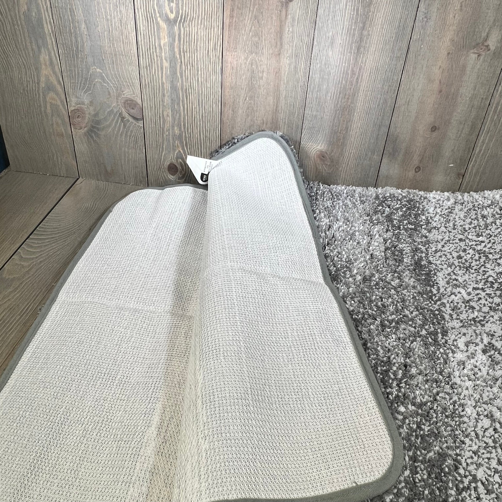 Non-slip grey OLANLY bathroom rug, showcasing plush shag and absorbent microfiber texture on a wooden floor.