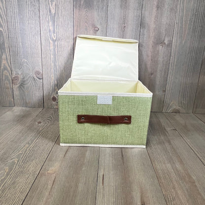 Green cotton linen storage box with lid open, faux leather handle, perfect for home organization, small size.