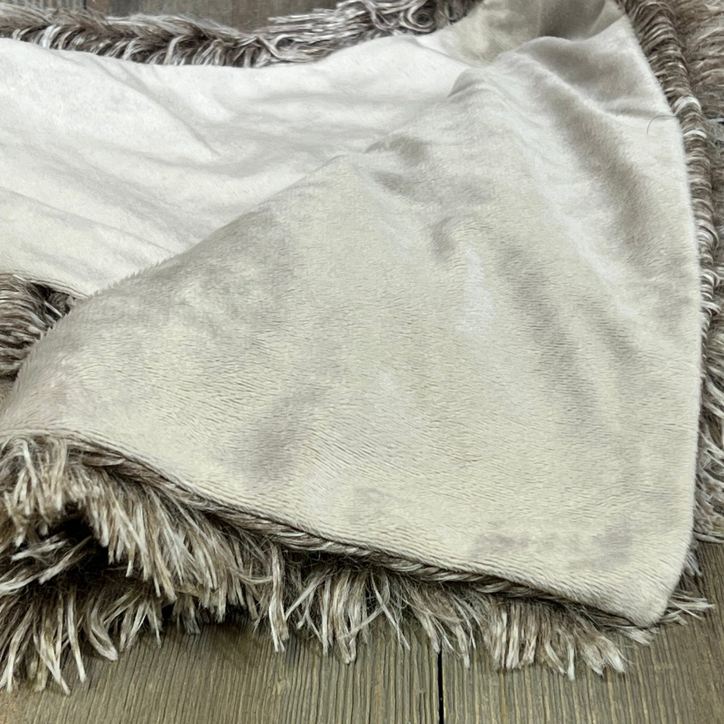 Shaggy faux fur pillow sham in ombre khaki, showcasing soft plush texture on rustic wooden background, 20"x26".