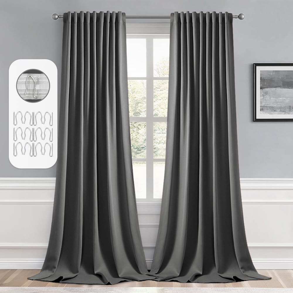Grey blackout curtains drape elegantly in a living room, featuring rod pocket and pinch pleat design for light blocking.