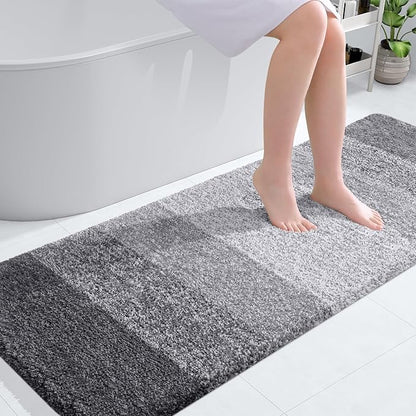 Grey OLANLY bathroom rug mat with plush shaggy texture, placed by a bathtub, showcasing its softness and absorbency.